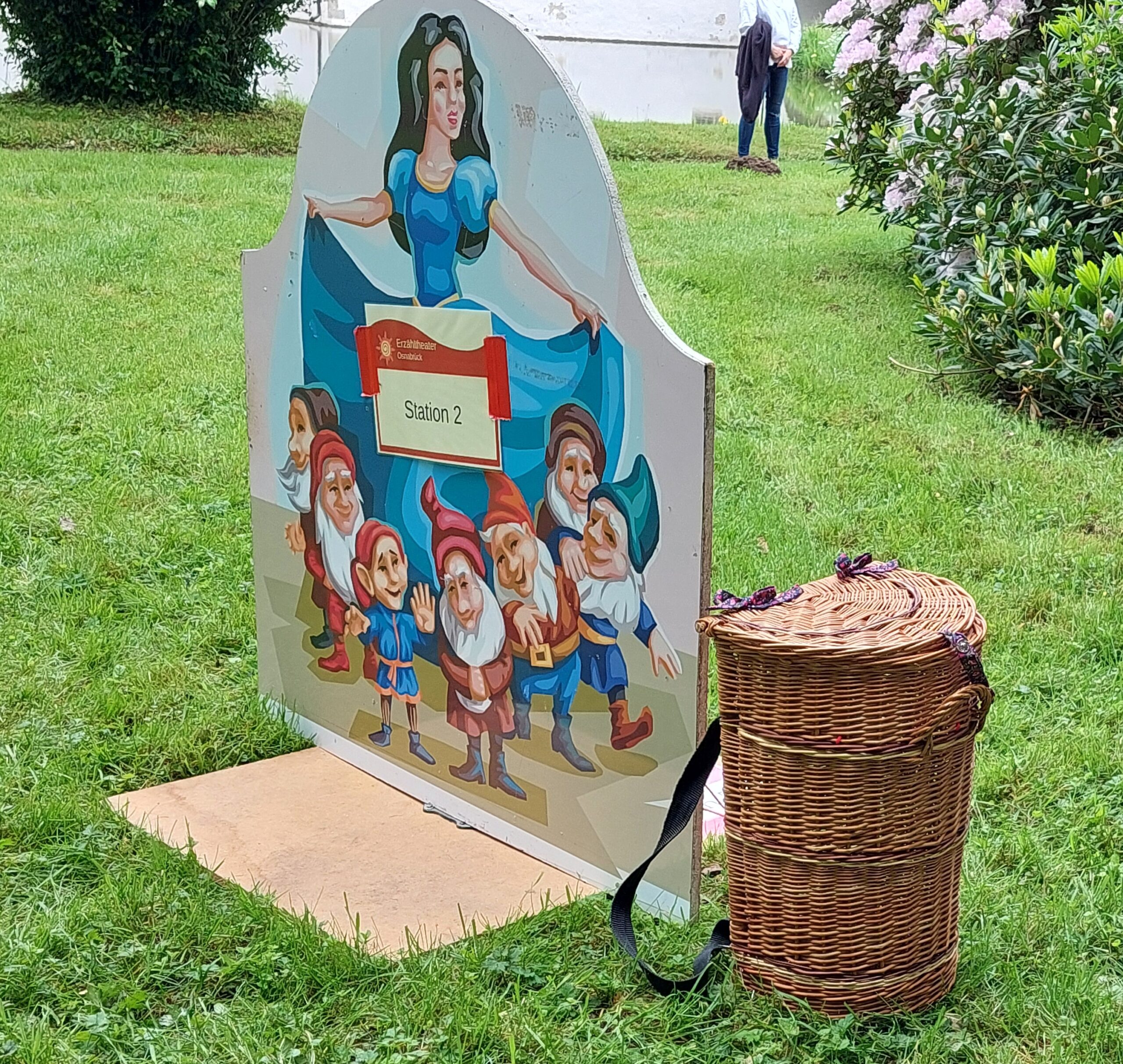 grüne Wiese, Märchenaufsteller vom Erzähltheater Osnabrück, Motiv: Schneewittchen und die sieben Zwerge, Kiepe aus Rattan, Märchenralley draußen